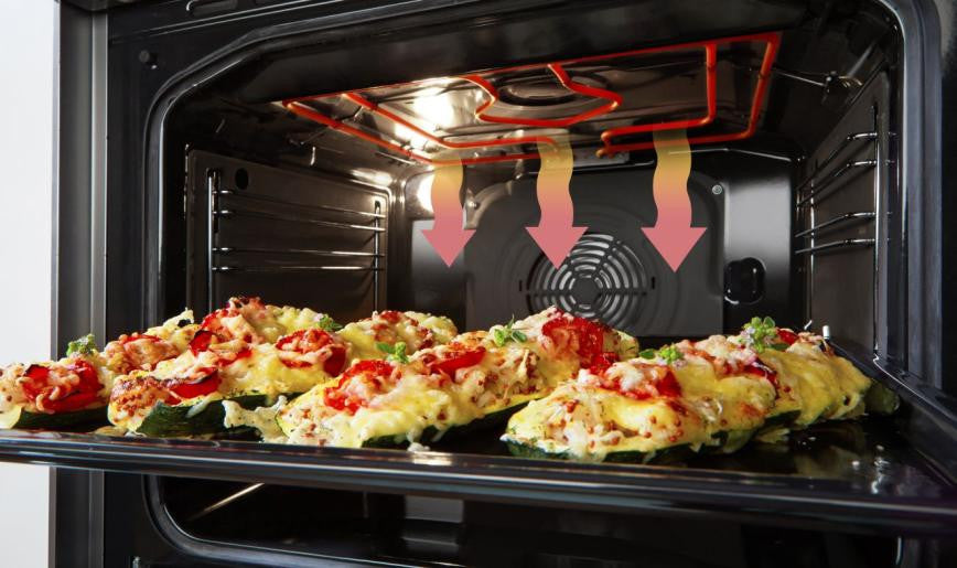 Open electric oven with stuffed vegetables baking on a tray inside showing heating elements and convection fan airflow